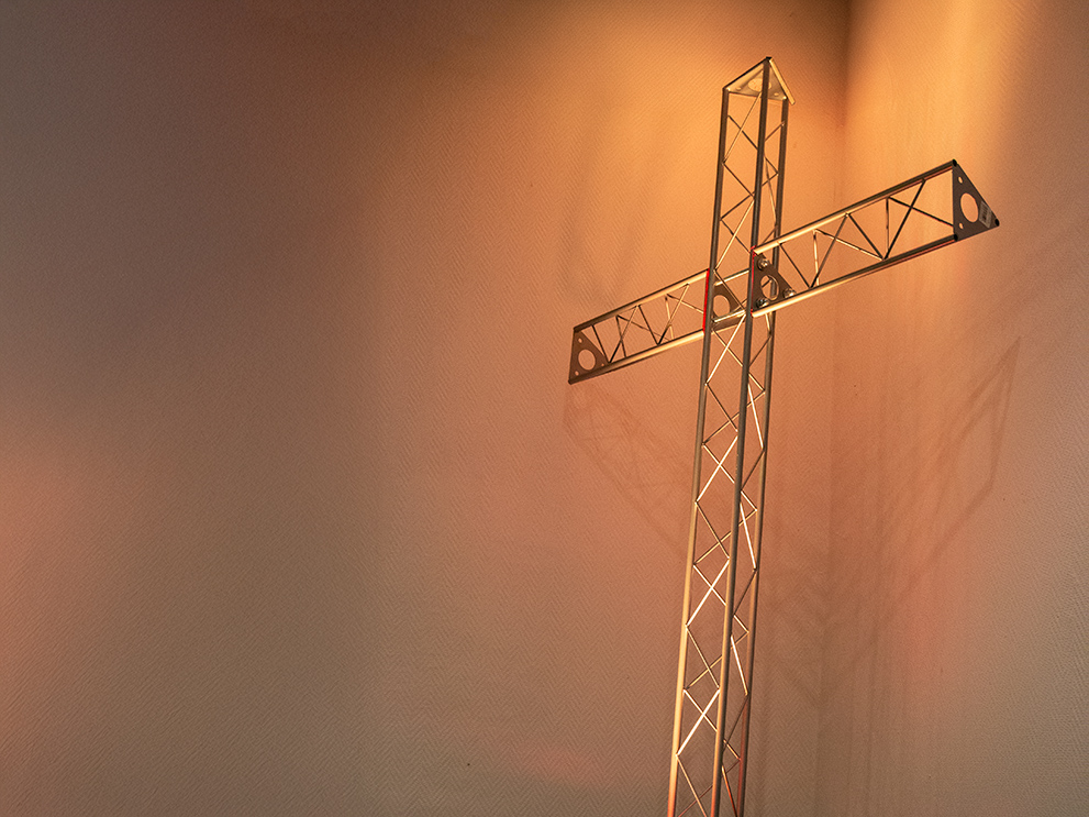 Von unten beleuchtetes Metallkreuz