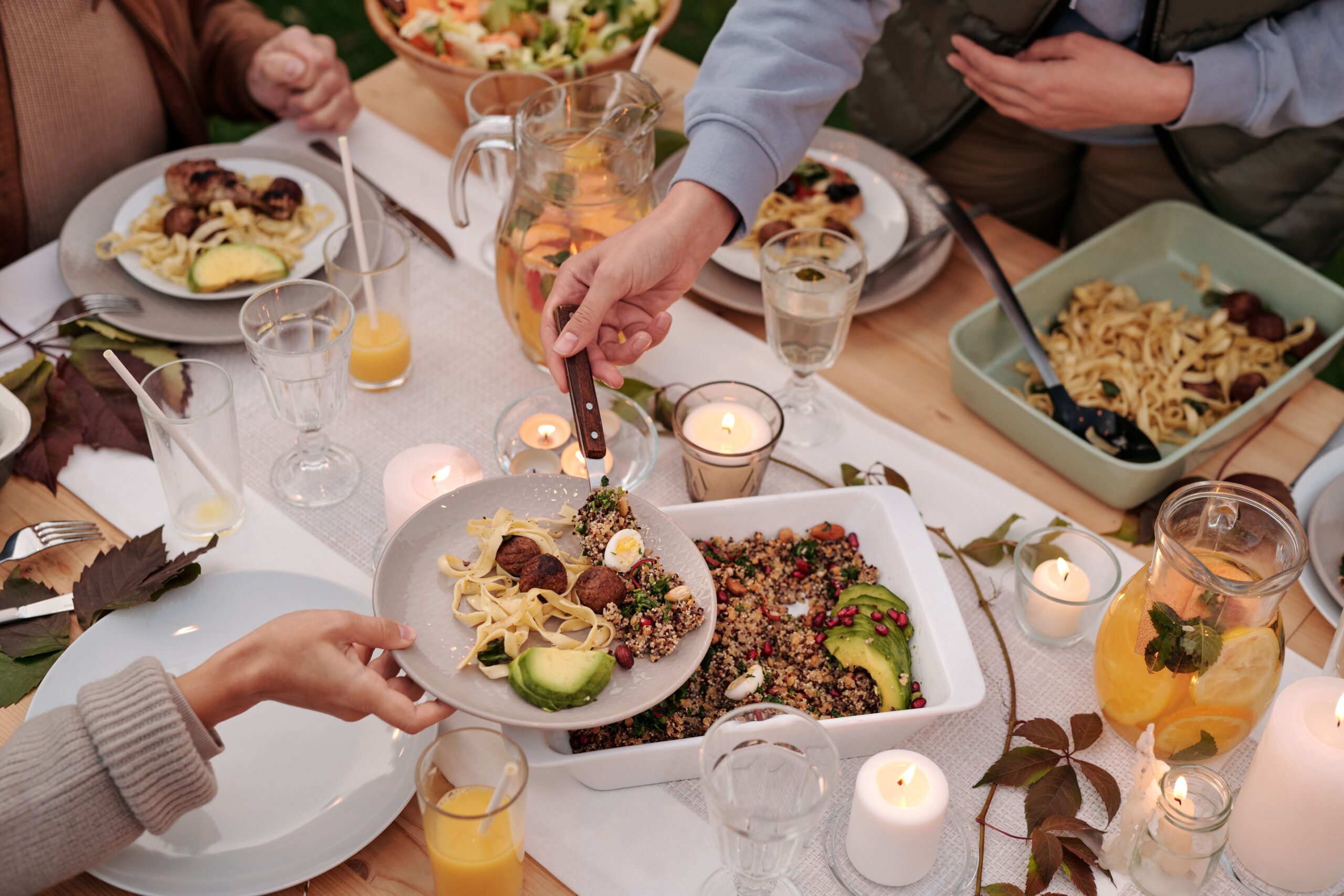 Menschen sitzen an einem gedeckten Tisch und essen gemeinsam